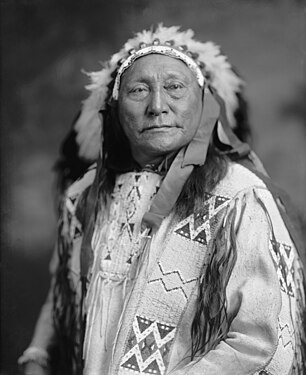 Black-and-white portrait photograph from the early 20th century of Hollow Horn Bear in traditional garb near the end of his life