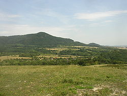 Pohled na Křížovou horu od jihozápadu, z návrší Bílá stráň. V pozadí vpravo vrch Liščín.
