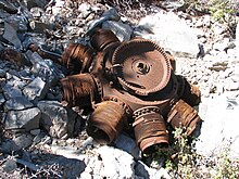 Rusted disk-shaped obviously damaged radial engine lying flat on the ground
