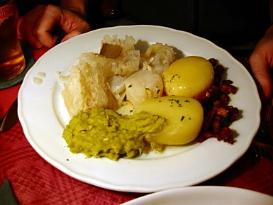 Traditional Norwegian lutefisk with potato, bacon, mashed peas.