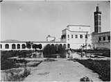 Vista del patio de la casa de fieras en la esquina suroeste del palacio, mirando al norte, con el minarete de la Mezquita Lalla Mina a la derecha (foto de 1913)