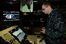 A sailor using an Xbox 360 controller to control the photonic masts of the USS Colorado (SSN-788) in 2018. It is the first submarine to use this Xbox controller. Manette de Xbox360, USS Colorado.jpg