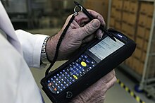 A large multifunction barcode scanner being used to monitor the transportation of packages of radioactive pharmaceuticals Package tracking barcode scanner 3.jpg