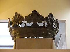 Photographie en couleurs d'une couronne derrière une vitrine.
