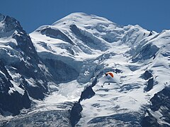 Panorama pohoří Mont Blanc nad šedými mraky pod modrou oblohou