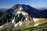 北側からの展望 別山から望む真砂岳（中央部）。真砂岳の北西斜面には巻き道の登山道がある。山頂直下の北東に延びる真砂尾根の稜線部に内蔵助山荘がある。その奥に立山（左から富士ノ折立、大汝山、雄山）。