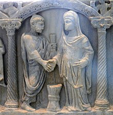 Roman couple joining hands; the knot in a bride's belt, symbolizing that her husband was "belted and bound" to her, was to be untied by him on the wedding night (from a 4th century sarcophagus) Roman marriage vows.jpg