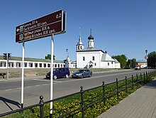 Photographie d'un panneau bilingue marron anglais russe indiquant le kremlin et les galeries commerciales.