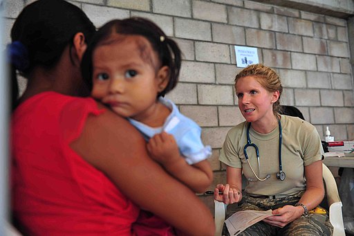 US Navy 110715-F-NJ219-161 Air Force Capt. Kristine Andrews, a pediatrician from Montgomery, Ala., explains common flu symptoms to a patient's moth