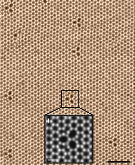 Vue au microscope électronique en transmission à balayage (STEM) d'une monocouche de diséléniure de tungstène à 500 °C montrant sa structure hexagonale avec ses défauts trifoliés[17].