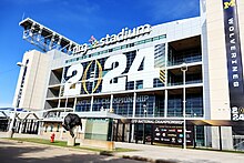 The exterior of a domed football stadium with a sign on its exterior reading "2024"