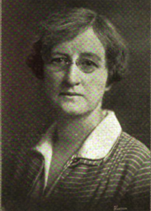 B&W portrait photo of a woman with short hair, wearing a white blouse and jacket