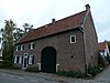 Bakstenen huis met segmentboogingang in Naamse steen