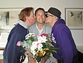 40歳の誕生日を祝ってもらい、友人たちから頬にキスをしてもらい笑顔を見せる男性