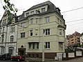 Mietshaus in halboffener Bebauung und in Ecklage, mit Einfriedung