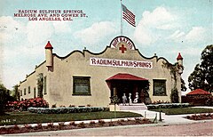 Caption: Radium Sulphur Springs - Melrose Ave. and Gower St., Los Angeles, Calif. Image: Lithographic postcard of one-story stucco building with Dutch Colonial style facade and an flagpole with American flag on the roof; four people sit on the front porch