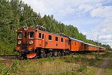 A Swedish boxcab locomotive hauling a train through the countryside
