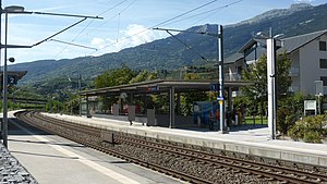 Double-tracked railway line with canopy-covered concrete platforms