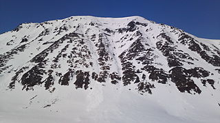 Storbukttind (literalmente, 'Gran monte de la bahía'; mide 1054 m y está al oeste de la ruta E6.