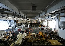 The hangar of George Washington during a replenishment at sea, 2009 US Navy 090529-N-1062H-042 Supply and deck department Sailors transfer cargo in the hangar bay of the aircraft carrier USS George Washington (CVN 73) during a replenishment-at-sea.jpg