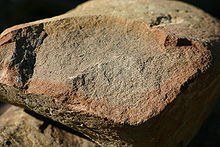A freshly broken rock shows differential chemical weathering (probably mostly oxidation) progressing inward. This piece of sandstone was found in glacial drift near Angelica, New York. Weathering 9039.jpg