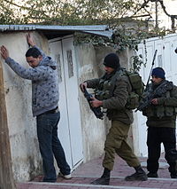 Israeli soldiers searching a Palestinian in Tel Rumeida, 2012 2012.01.16.HebronGilbertCheckpoint.2.JPG