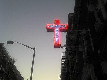 English: A "Jesus Saves" neon cross ...