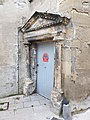 La porte avec son fronton et ses deux colonnes.