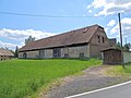 Gutshof mit Wohnstallhaus (Umgebinde), paralleler Scheune mit rechtwinkligem Anbau und zwei Seitengebäuden an der Straße