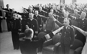 Admiral Karl Donitz (center, back to camera) returning the Nazi salute of assembled Wehrmacht officers, in France, 1941 Bundesarchiv Bild 101II-MW-4012-04, Frankreich, Donitz bei Offizieren.jpg