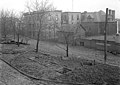 A black-and-white photo of the pumping station in 1919. The building is in the background while the foreground shows wooden rectangles in the ground (where the oil tanks were buried).