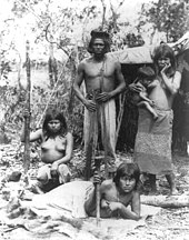 Humans often live in family-based social structures Indian family in Brazil posed in front of hut.jpg