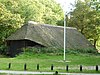 Een schaapskooi van gepotdekselde houten delen met rieten dak, mooi gelegen in het geboomte