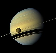 Les anneaux ne sont pas visible car la sonde est dans le plan, Titan étant au premier plan.