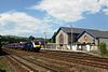 A train at Totnes station passing the unused atmospheric railway engine house in 2013