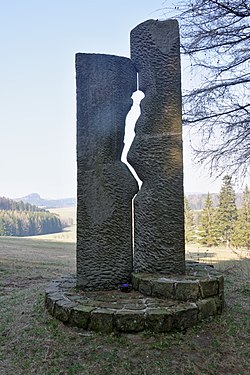 Fotografi av det tysk- tsjekkiske forsoningsmonumentet på berget Buková hora ved byen Teplice nad Metují. Monumentet viser en silhuett av et menneske som presses mellom to steinblokker.