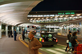 The North Wing Building soars on the head of passengers which are coming and going busily.