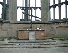 The Charred cross, with the "Father Forgive" inscription behind. Coventry Cathedral burnt cross.jpg