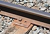 a dogspike holding a rail to a wooden sleeper with a steel baseplate in between