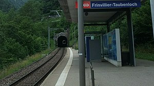 Canopy-covered platform next to single-track railway line leading into tunnel