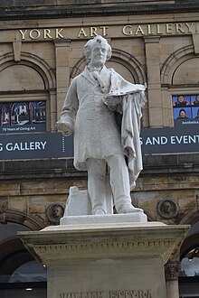 Statue en pied d'un peintre tenant une palette, devant un bâtiment indiquant "York Art Gallery".