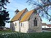 Eine Kirche mit rotem Ziegeldach und Glockenturm am fernen Ende