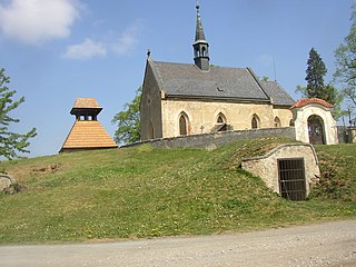 Unterkellerter Hügel mit Kirche St. Nikolaus, Friedhof und Glockenturm