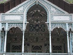 Detalle de un balcón en madera azul y la decoración de su interior.