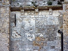 Photographie d'un bas-relief partiellement effacé.