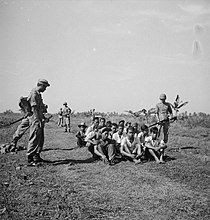 Dutch soldiers in the East Indies during the Indonesian National Revolution, 1946 Een groep gevangenen zit op de grond, bewaakt door soldaten voorbeeld van goe..., Bestanddeelnr 15865.jpg