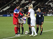 United States captain Abby Wambach (left, in red) and England captain Steph Houghton (right, in white) shake hands before kickoff, 2015 England Women's Vs USA (18500761141).jpg