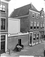 Gezicht op het fotoatelier van Goedeljee aan de Hogewoerd nrs. 160-162a met rechts het huis en links een muur met ingang (glasnegatief, gemaakt door Goedeljee, ca. 1900)