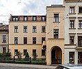 Mietshaus in geschlossener Bebauung, zur Hälfte zurückgesetzt, mit Vorgarten