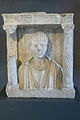 Busto funerario romano del II secolo raffigurante un giovane uomo in un'edicola. Museo archeologico nazionale di Aquileia.